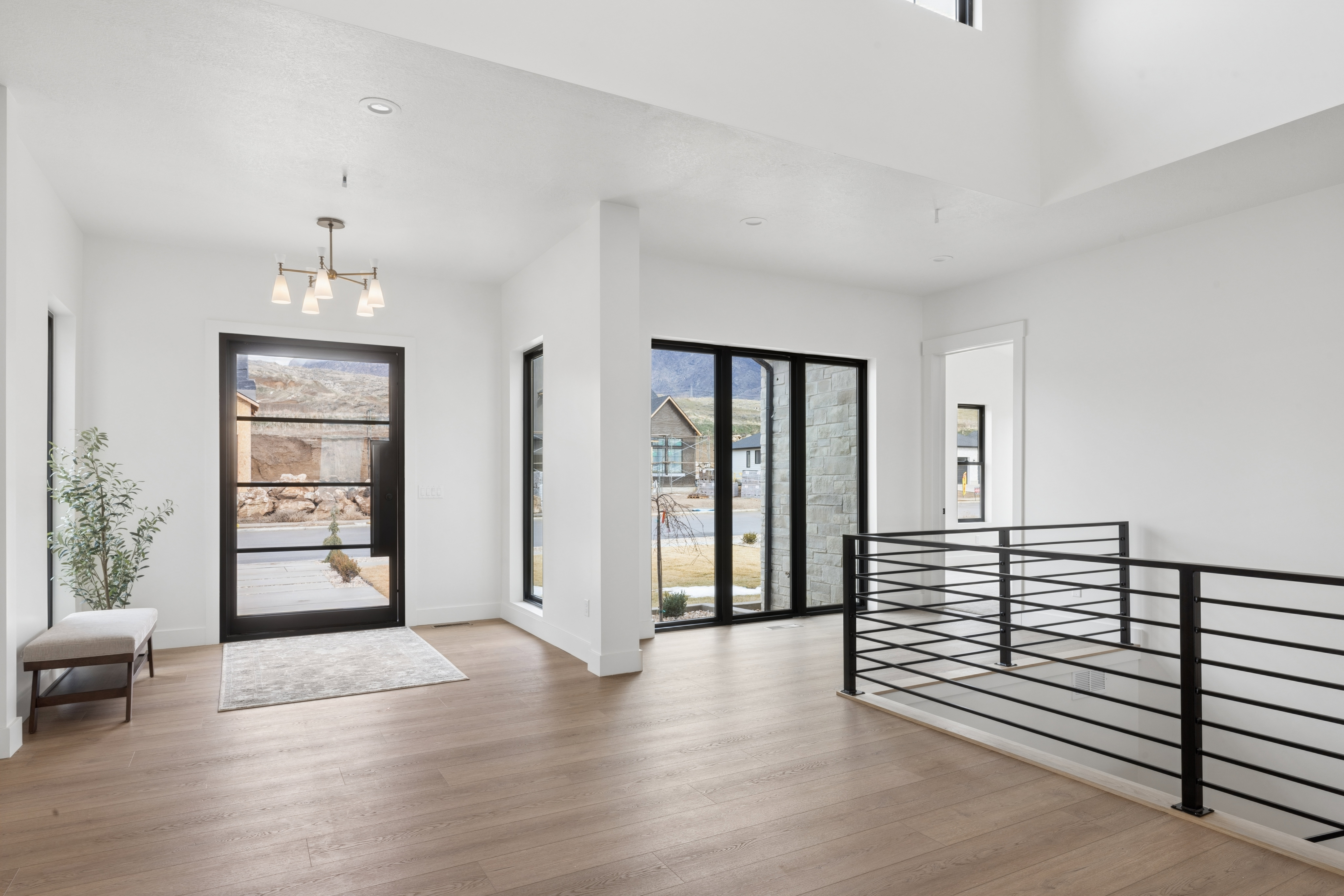 Foyer with light wood-style floors and hanging lights
