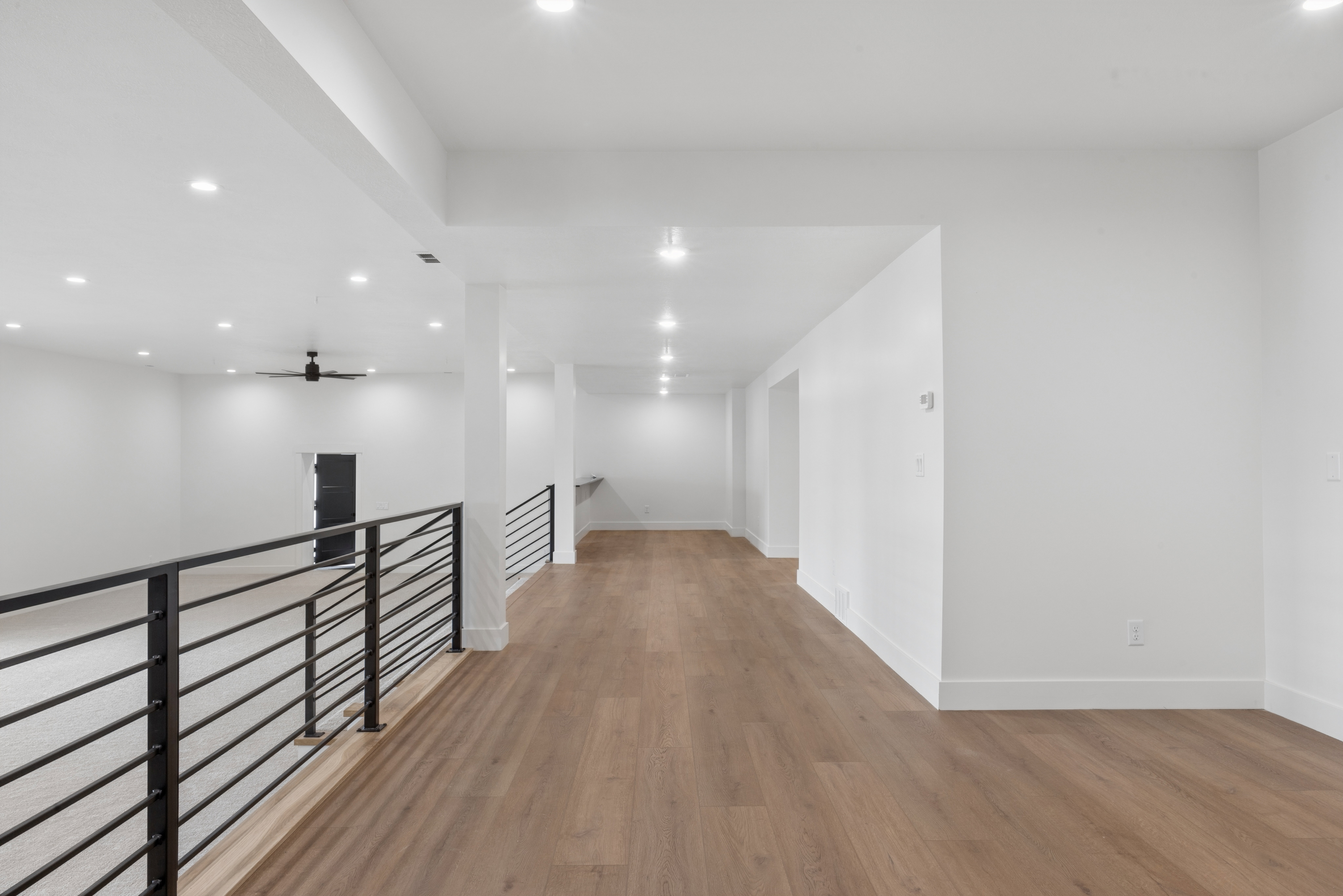 Corridor featuring an upstairs landing, light wood-style floors, and recessed lighting