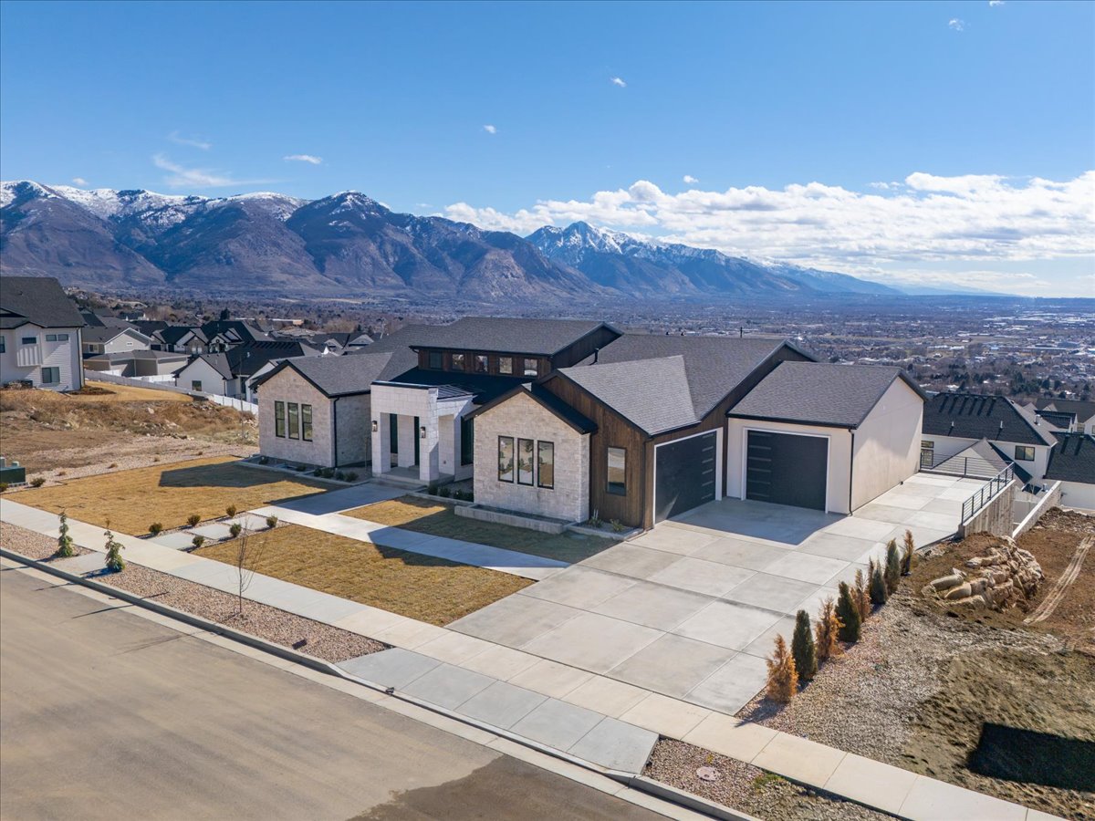 View of front of home featuring a residential view, an attached garage, a mountain view, and concrete driveway