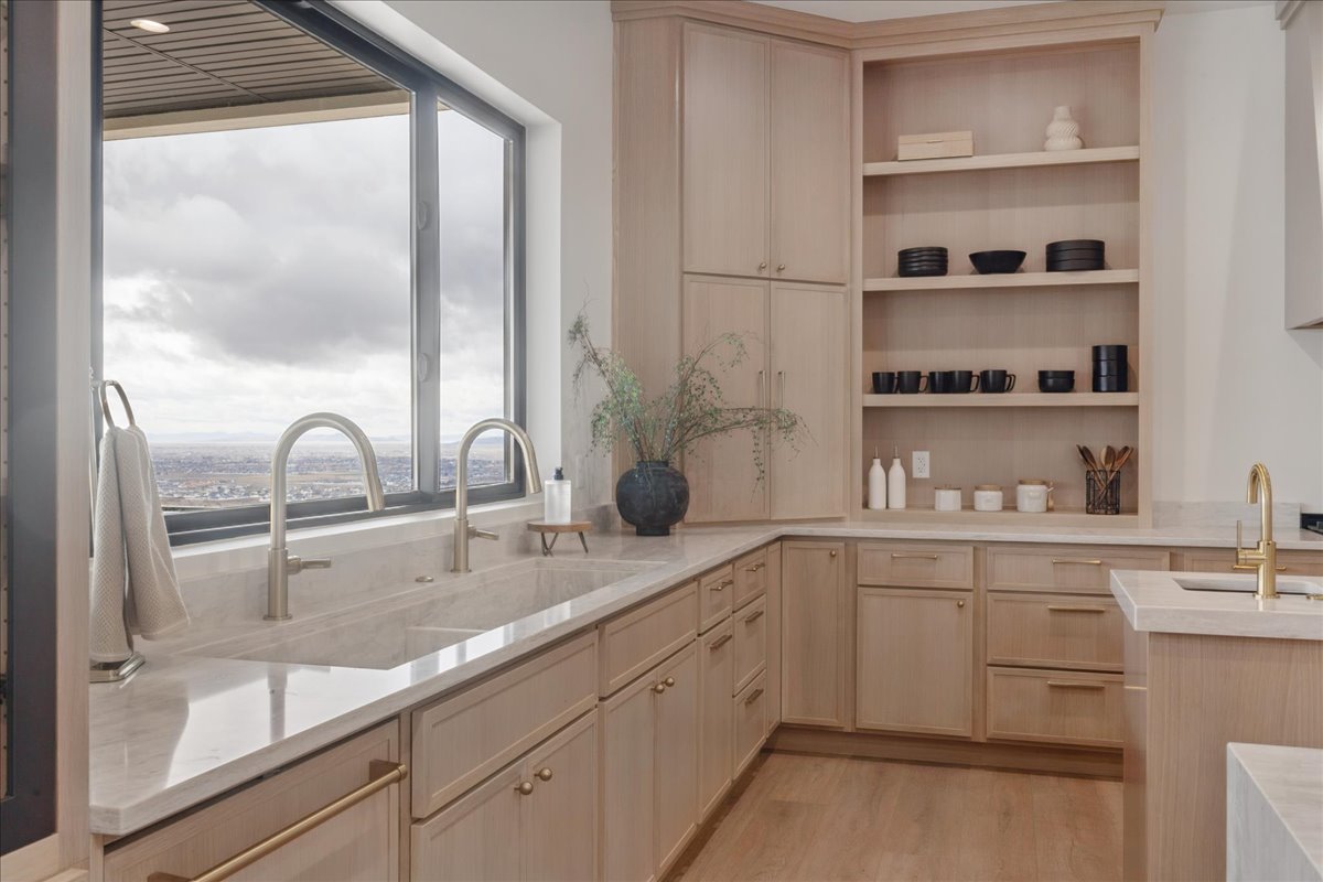 Kitchen with light stone countertops, light wood finish cabinetry, and light wood-style flooring