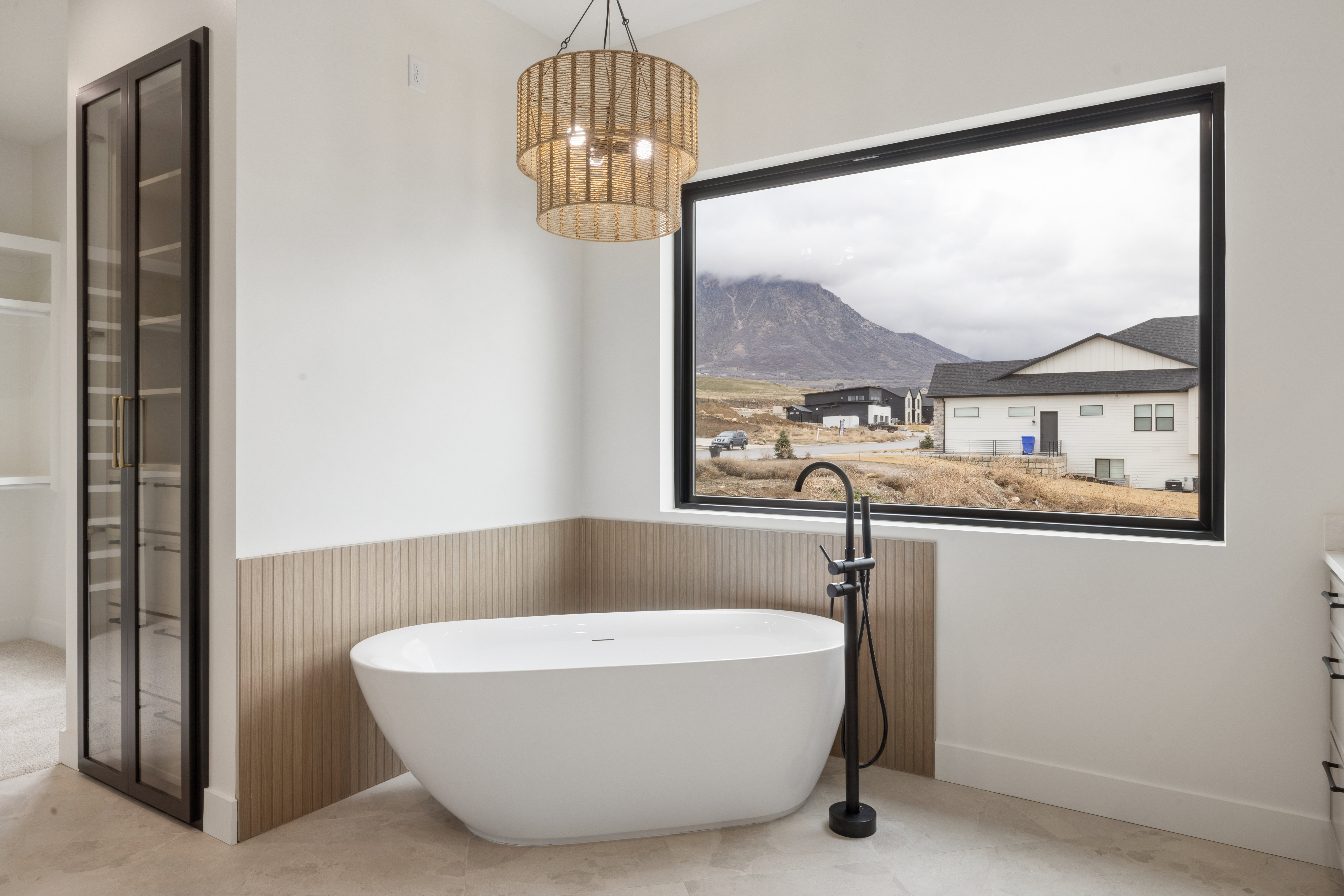 Full bath with wainscoting, a mountain view, vanity, a freestanding bath, and a walk in closet