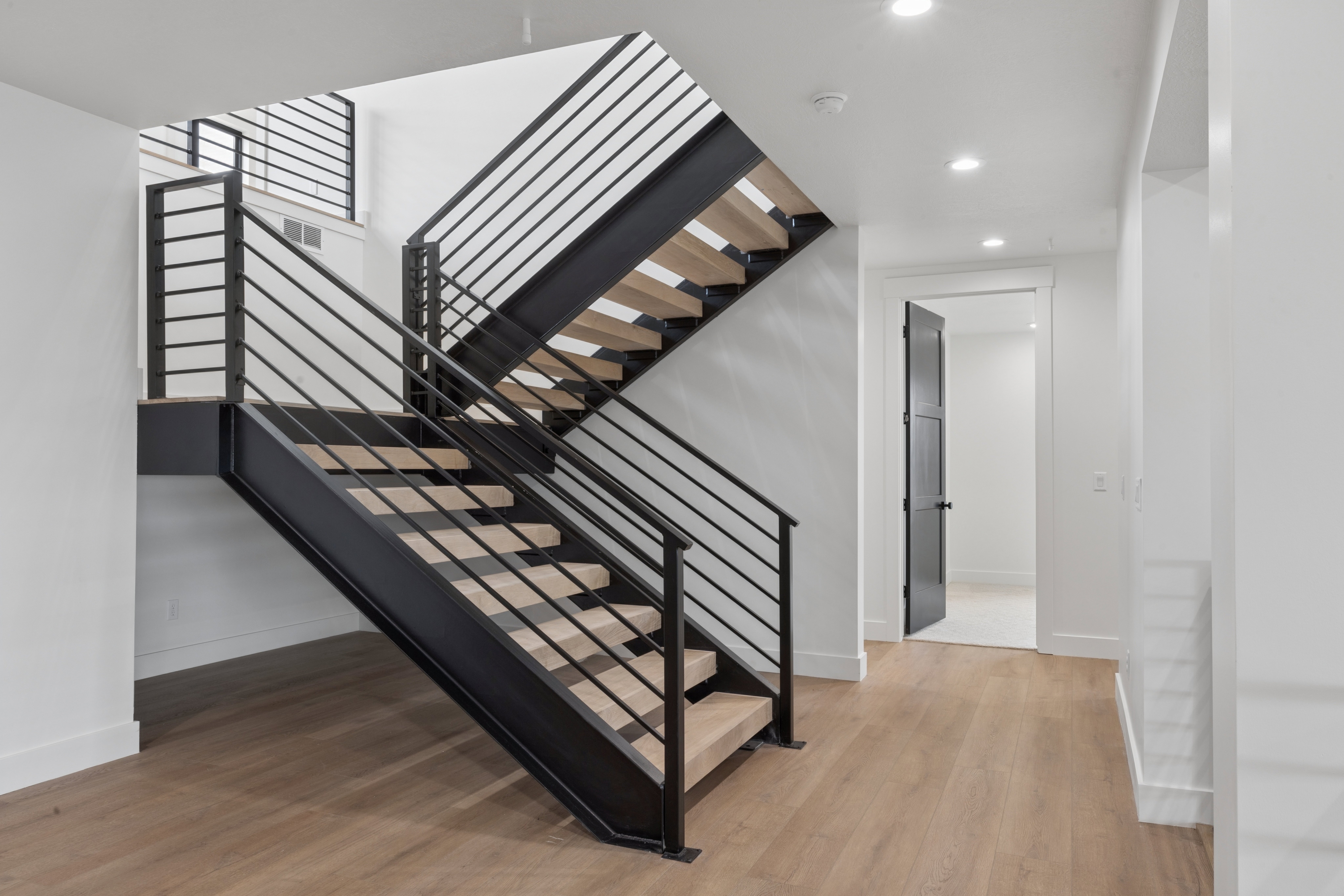 Staircase featuring wood finished floors and recessed lighting