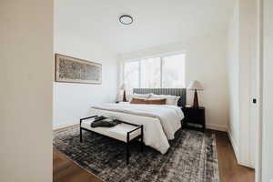 Bedroom with wood finished floors and baseboards