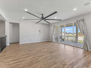 Great room featuring light wood finished floors, ceiling fan, recessed lighting, and a residential view