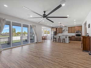 Unfurnished great room featuring a ceiling fan, light wood-style floors, and recessed lighting