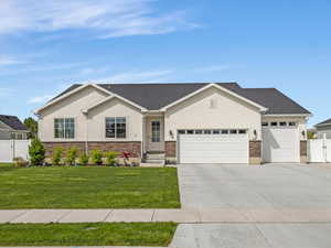 Single story home featuring a gate, an attached garage, stucco siding, concrete driveway, and stone siding