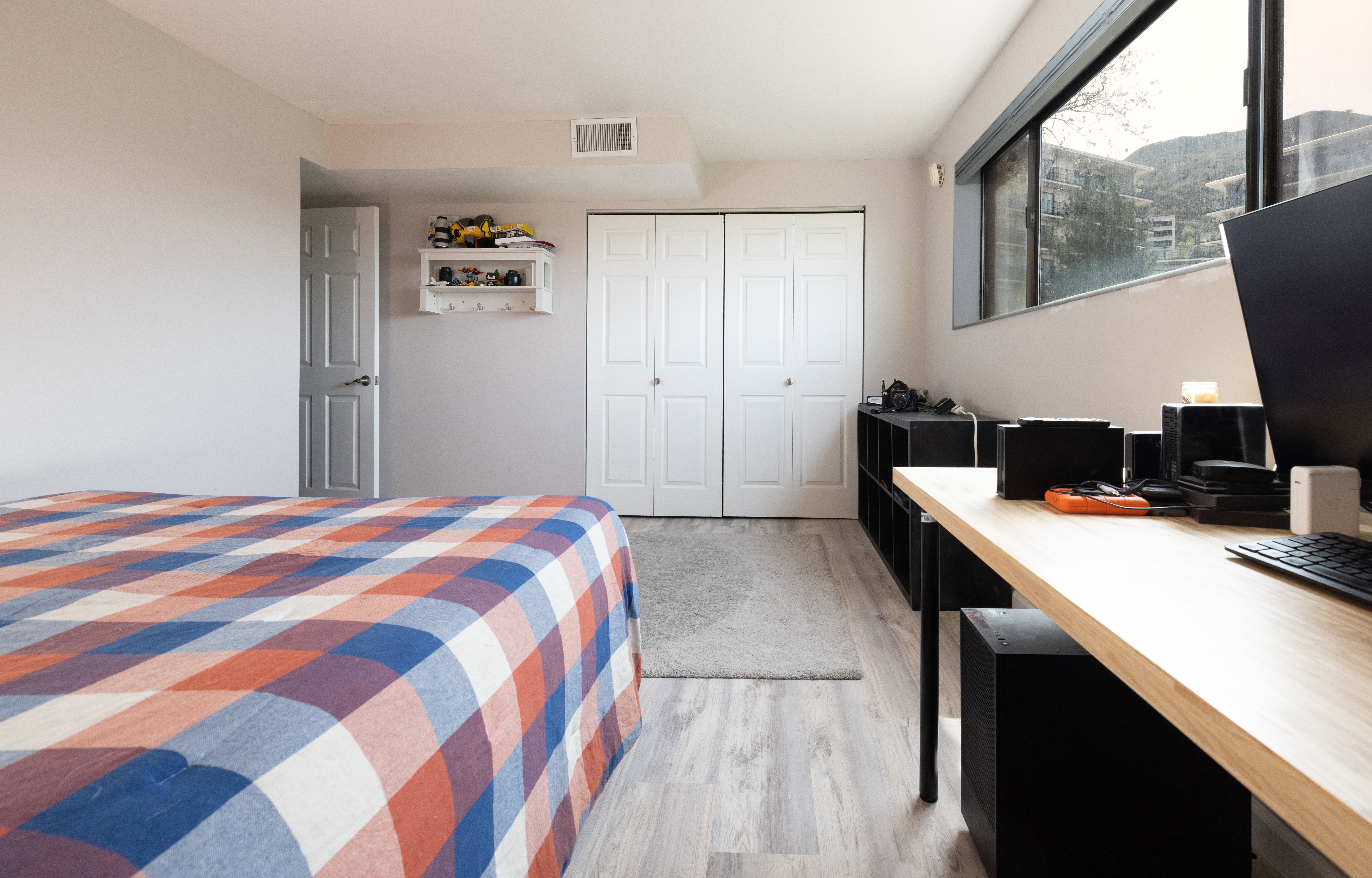 Bedroom featuring light wood-style floors, a closet, and a desk