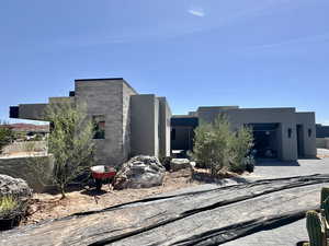 View of front of property featuring stucco siding, decorative driveway, and a garage