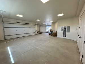 Garage with electric panel and baseboards