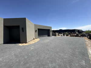 View of front of home featuring stucco siding and decorative driveway