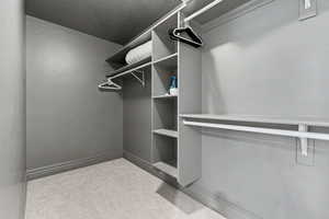 Walk in closet with light carpet