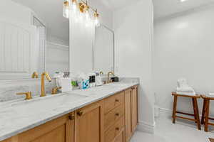 Full bathroom with double vanity and light tile patterned flooring