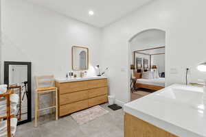 Bathroom with ensuite bathroom, two vanities, and recessed lighting