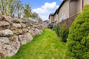 View of grassy yard with a deck