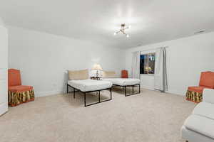 Living area with light colored carpet and a textured ceiling