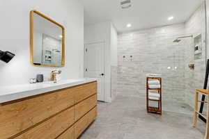 Full bathroom with vanity, walk in shower, and recessed lighting