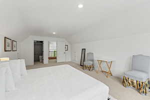 Bedroom featuring light carpet, vaulted ceiling, a walk in closet, and recessed lighting