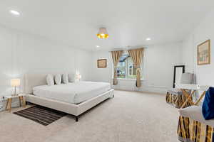 Bedroom featuring a decorative wall, light colored carpet, and recessed lighting