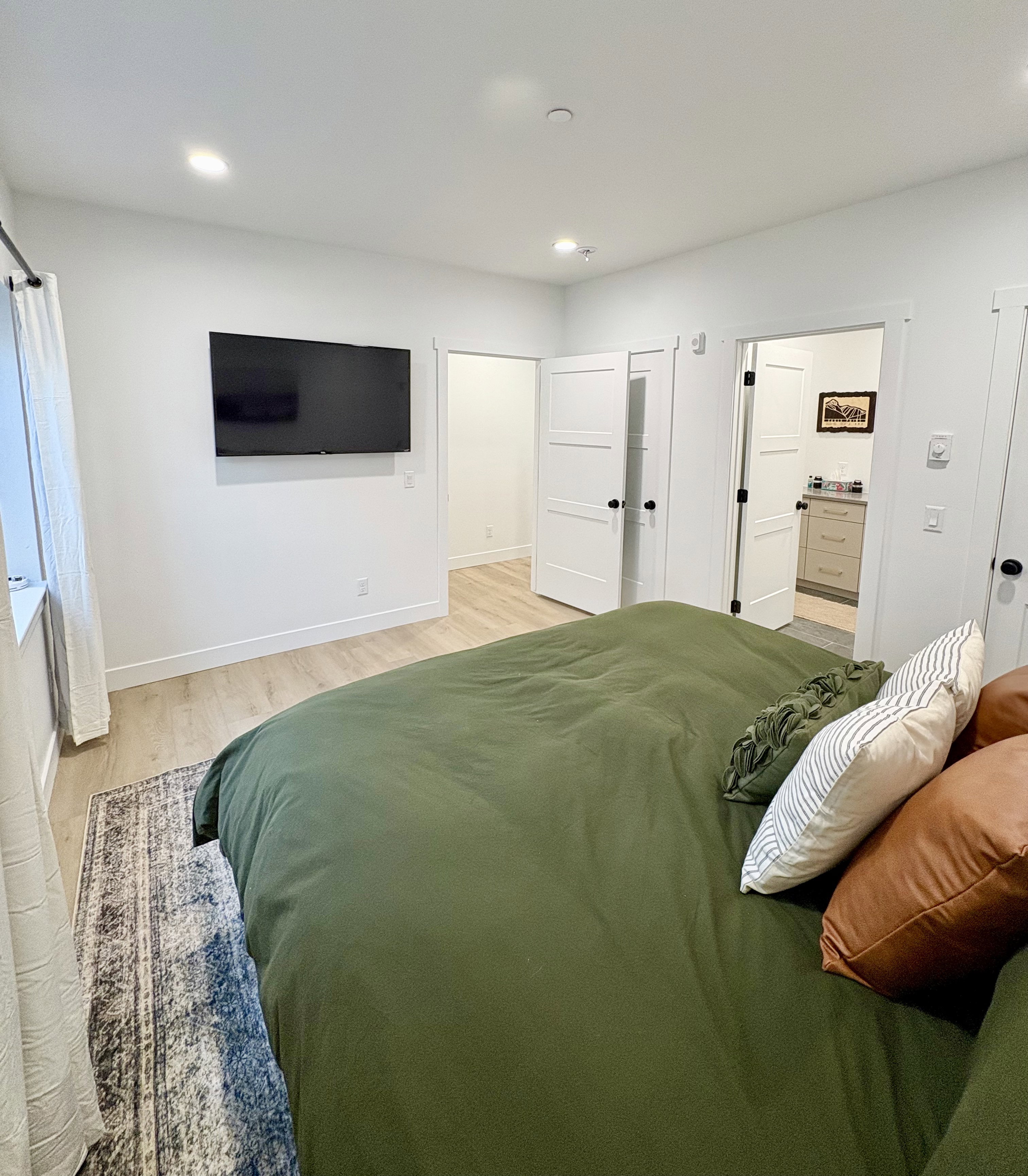 Bedroom featuring light wood-style flooring, ensuite bathroom, and recessed lighting