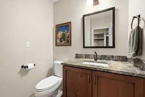 Half bath featuring vanity and a textured wall