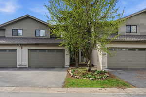 Traditional-style home with a shingled roof, asphalt driveway, and a garage