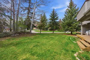 View of green lawn featuring a deck