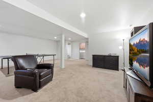 Living area featuring light colored carpet and recessed lighting