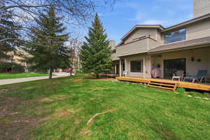 View of grassy yard with a wooden deck