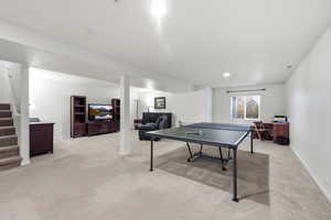 Rec room featuring light colored carpet and baseboards