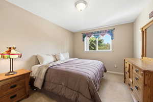 Bedroom featuring light carpet and baseboards