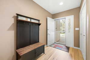 Mudroom featuring light wood-style floors and baseboards