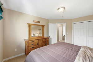 Bedroom with light carpet and a closet