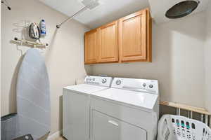 Laundry area with cabinet space and separate washer and dryer