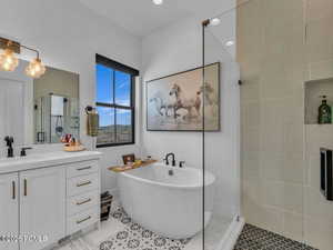 Full bathroom with vanity, a stall shower, light tile patterned flooring, a freestanding tub, and recessed lighting