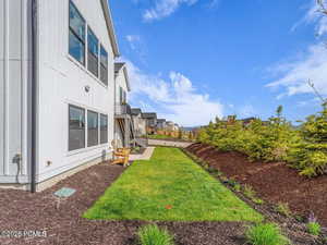 View of green lawn with a balcony and a residential view