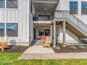 Entrance to property featuring board and batten siding and a patio