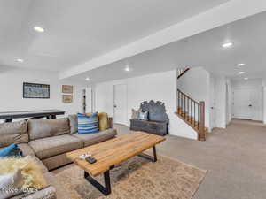 Living area featuring light carpet, recessed lighting, and a textured ceiling