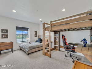 Bedroom with light carpet, an office area, recessed lighting, and a textured ceiling