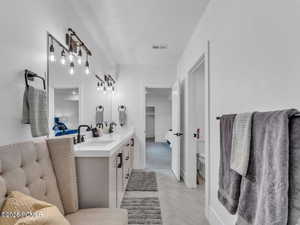 Bathroom with double vanity, connected bathroom, and parquet flooring