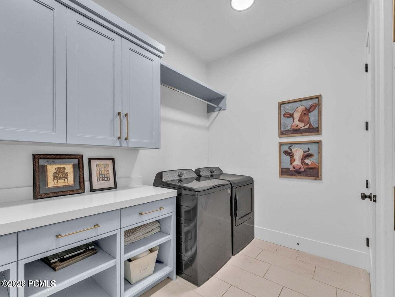Laundry room with independent washer and dryer, cabinet space, and light tile patterned floors