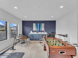 Recreation room featuring light wood-style floors, wine cooler, and recessed lighting
