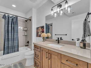 Bathroom featuring vanity and shower / bath combination with curtain