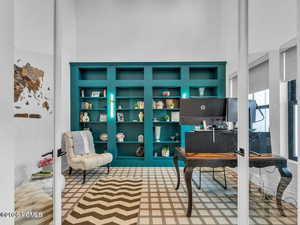 Home office with a high ceiling and built in features