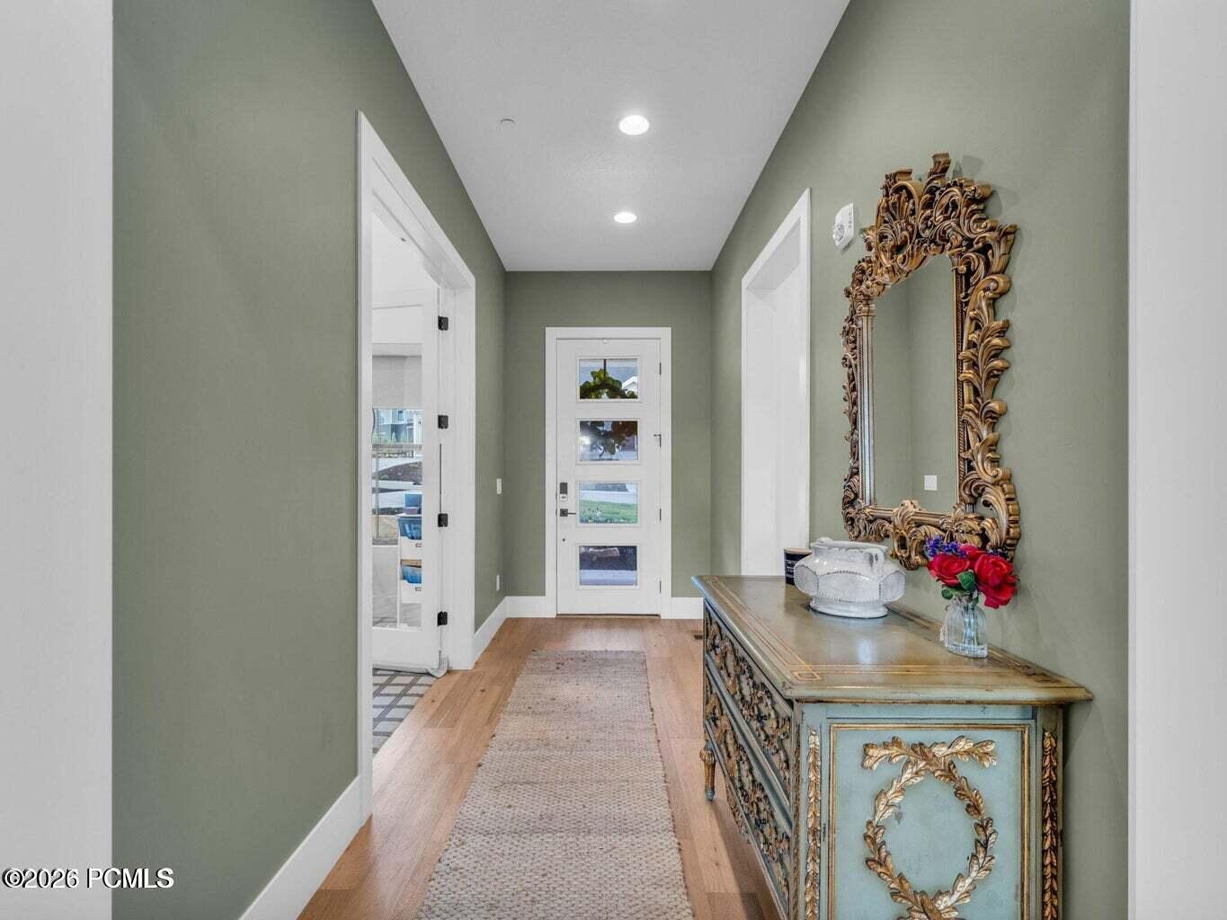 Doorway to outside with wood finished floors and recessed lighting