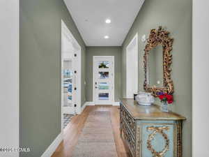 Doorway to outside with wood finished floors and recessed lighting