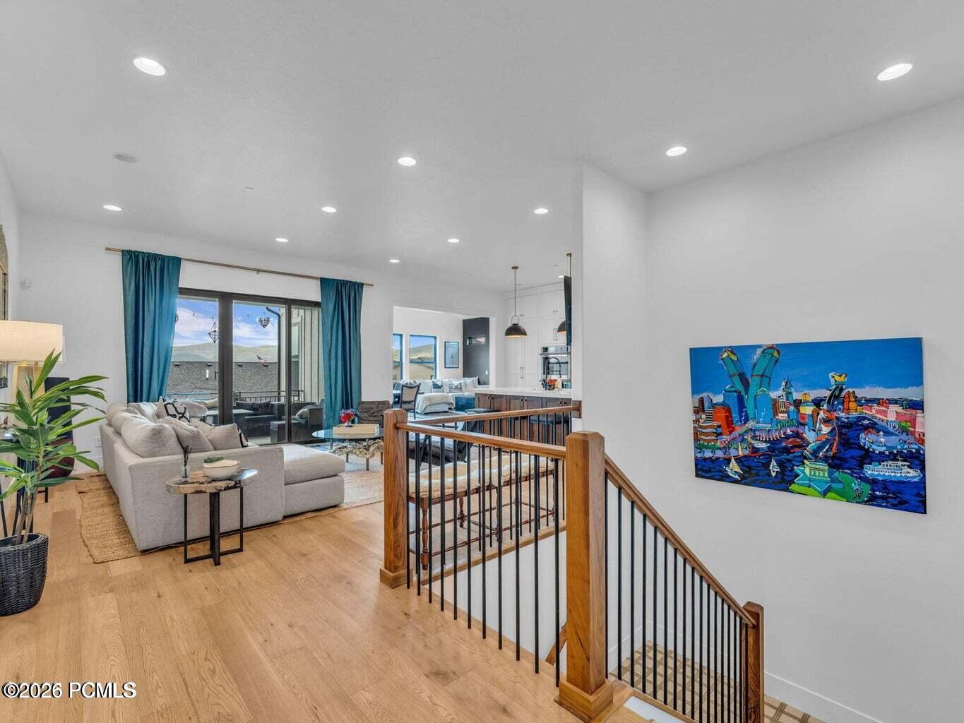 Living room with light wood-type flooring and recessed lighting