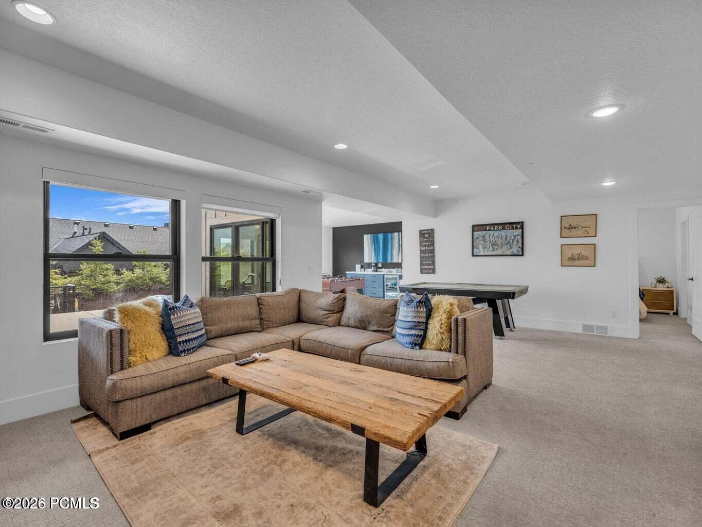 Living room with light colored carpet, a textured ceiling, and recessed lighting