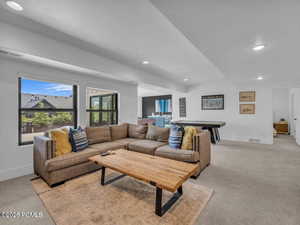 Living room with light colored carpet, a textured ceiling, and recessed lighting
