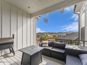 Deck featuring an outdoor lounge area, a grill, a residential view, and a mountain view