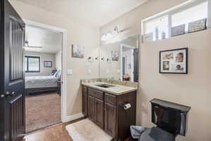 Bathroom with vanity, light wood finished floors, a textured ceiling, ensuite bath, and ceiling fan